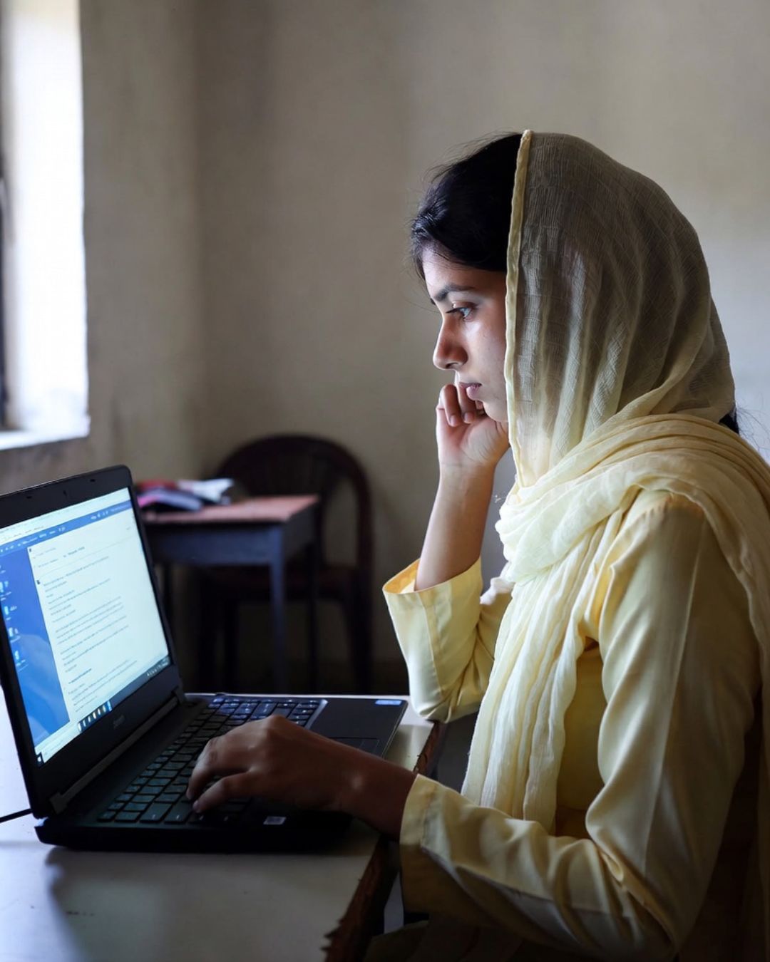 Young woman using a laptop during practical AI learning